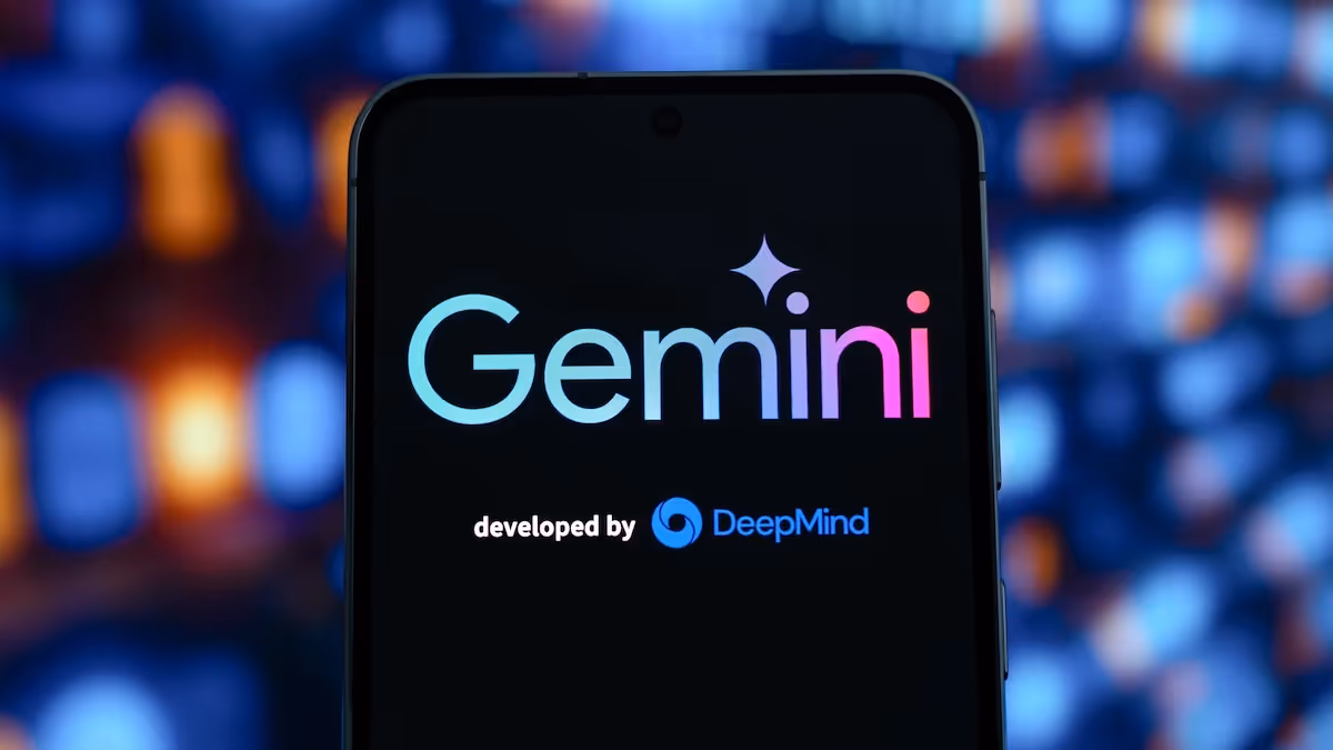 Een smartphone scherm met het kleurrijke Google Gemini logo en de tekst "developed by DeepMind" tegen een sfeervolle bokeh achtergrond van stadslichten.