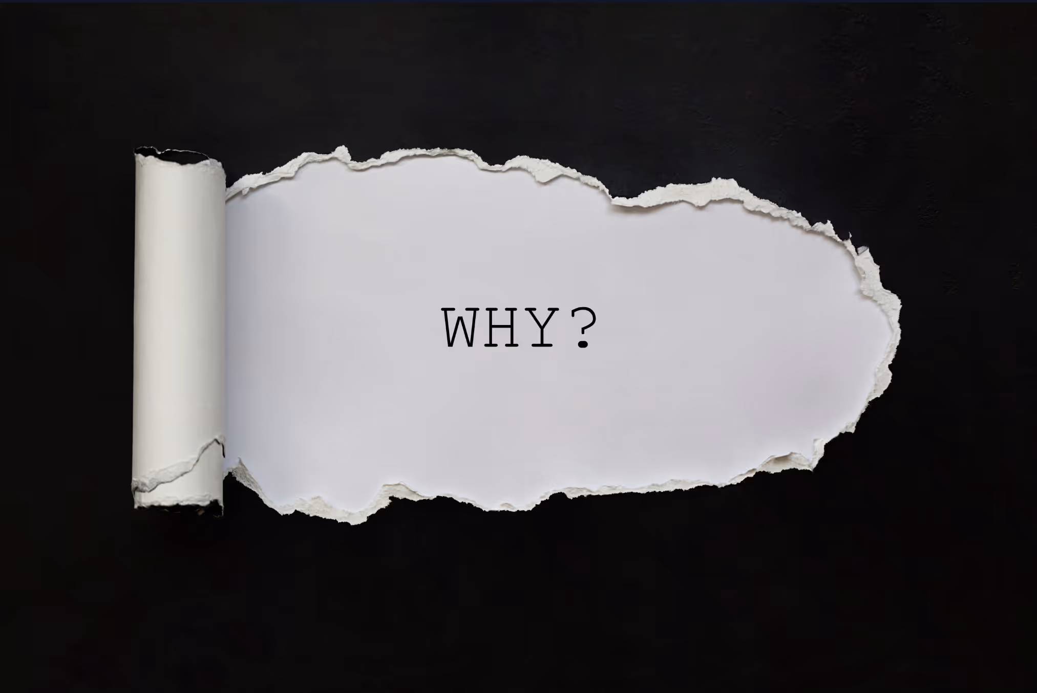 Een minimalistische afbeelding van een zwart oppervlak met een gescheurde witte opening waarin de vraag "WHY?" in een typemachine-lettertype staat.