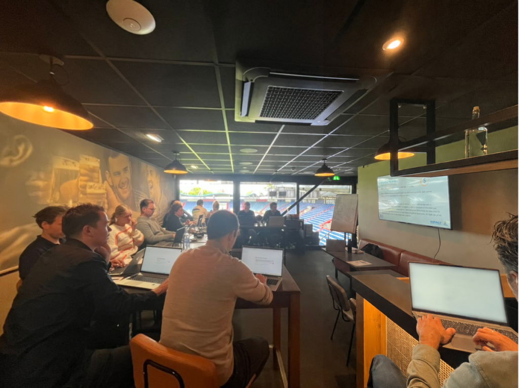 Medewerkers volgen met laptops een praktische AI-training van Lumans en Smarter.