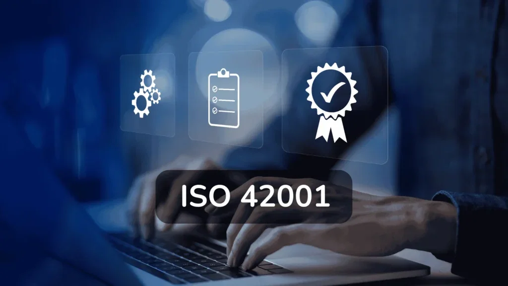 Icoontjes voor procesoptimalisatie (tandwielen), een checklist en een kwaliteitskeurmerk zweven boven de handen van een professional die op een laptop typt, met de tekst ISO 42001 in beeld.